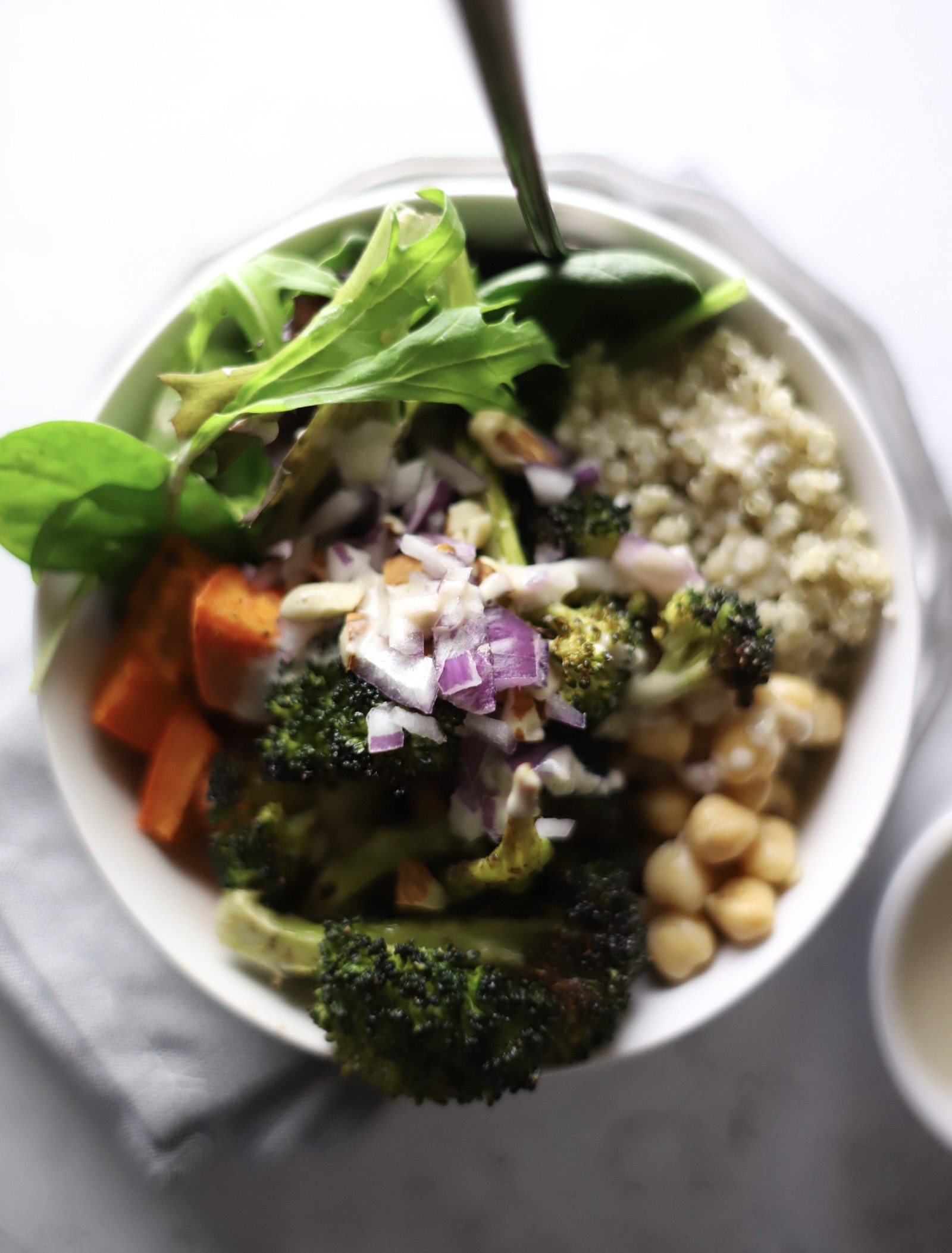 buddha bowl containing quinoa, chickpeas, roasted broccoli and sweet potato