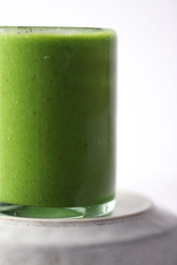 banana kiwi green smoothie in a glass cup