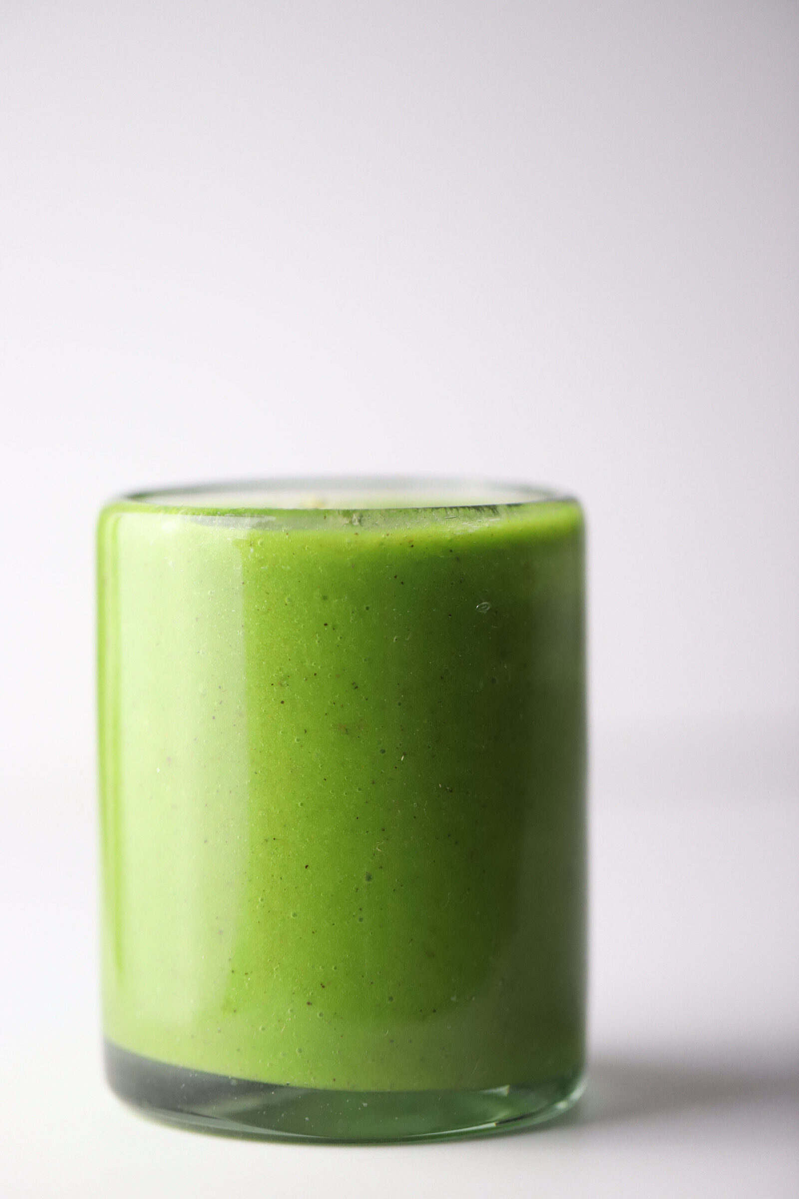 kiwi banana green smoothie in a glass cup